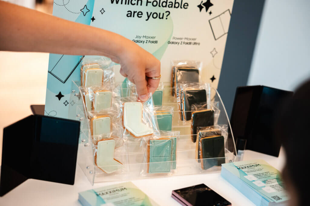 Hand pakt koekje in vorm van nieuwe Samsung-toestellen van display